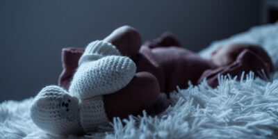 Стоковая иллюстрация: Вязаные пинетки на ножках младенца